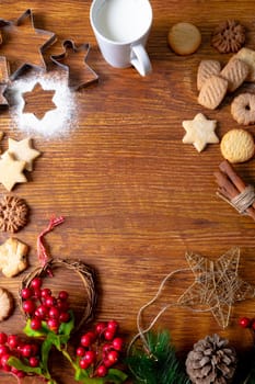 Composition of christmas decorations with mug, christmas cookies and copy space on wooden background. christmas, tradition and celebration concept.