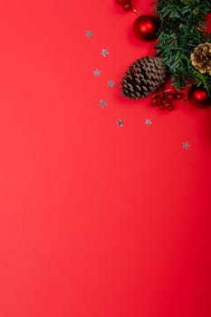 Composition of christmas decorations with pine cones, stars and copy space on red background. christmas, tradition and celebration concept.