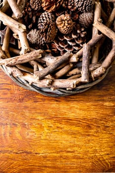 Composition of christmas decorations with sticks, pine cones and copy space on wooden background. christmas, nature, tradition and celebration concept.