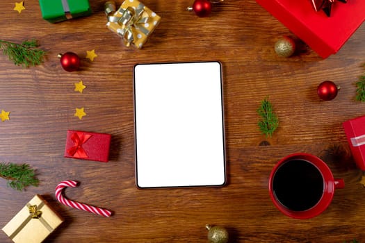 Composition of tablet with copy space and christmas decorations on wooden background. christmas, communication, tradition and celebration concept.