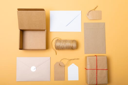 Composition of boxes, envelopes and gift tags on yellow background. christmas, gifts, tradition and celebration concept.