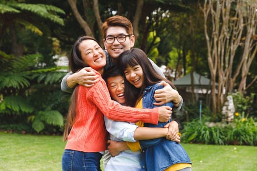 Portrait of happy asian parents, son and daughter smiling outdoors in garden. family enjoying leisure time together at home.