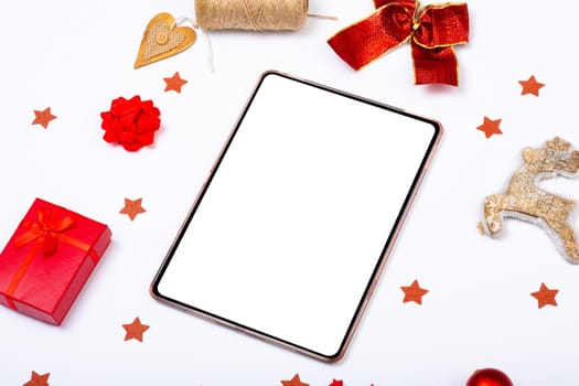 Composition of tablet with copy space and christmas decorations on white background. christmas, tradition and celebration concept.