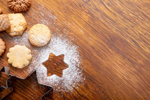 Composition of ginger man cookie cutters with christmas cookies and copy space on wooden background. christmas, tradition and celebration concept.