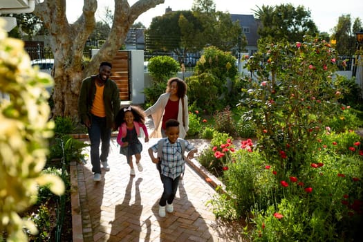 Happy african american family returning back home. family time, having fun together at home and garden.