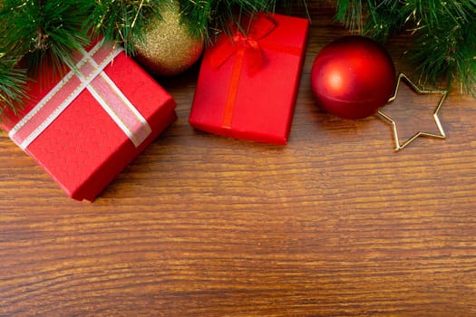 Composition of christmas decorations with presents, baubles and copy space on wooden background. christmas, tradition and celebration concept.