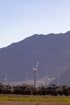 General view of wind turbines in countryside landscape with cloudless sky. environment, sustainability, ecology, renewable energy, global warming and climate change awareness.