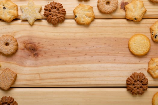 Composition of christmas cookies and copy space on wooden background. christmas, tradition and celebration concept.