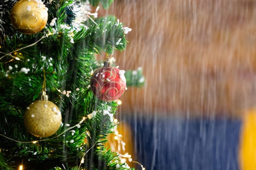 Composition of snow falling on christmas tree with baubles on blurred background. christmas, tradition and celebration concept.
