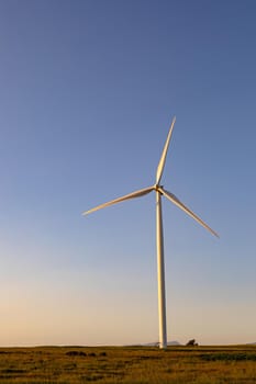 General view of wind turbine in countryside landscape with cloudless sky. environment, sustainability, ecology, renewable energy, global warming and climate change awareness.