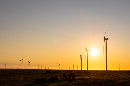 General view of wind turbines in countryside landscape during sunset. environment, sustainability, ecology, renewable energy, global warming and climate change awareness.