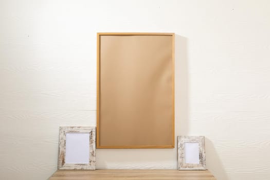 Composition of brown card in frame with copy space and decorations on white background. interior design and decor concept.