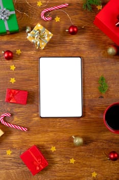 Composition of tablet with copy space and christmas decorations on wooden background. christmas, communication, tradition and celebration concept.