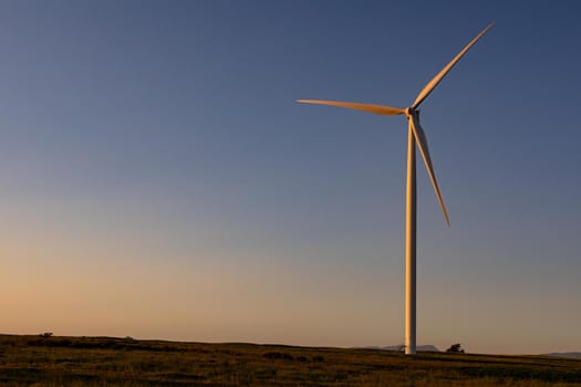 General view of wind turbine in countryside landscape during sunset. environment, sustainability, ecology, renewable energy, global warming and climate change awareness.