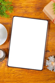 Composition of tablet with copy space and christmas decorations on wooden background. christmas, communication, tradition and celebration concept.