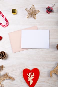 Composition of white card with copy space, envelope and christmas decorations on wooden background. christmas, tradition and celebration concept.