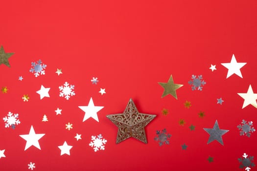 Composition of christmas decorations with stars, snowflakes and copy space on red background. christmas, tradition and celebration concept.