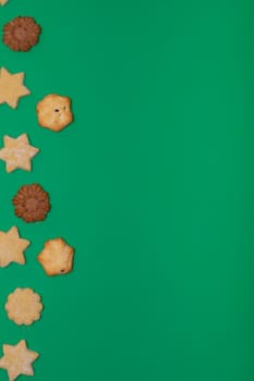 Composition of christmas cookies and copy space on green background. christmas, tradition and celebration concept.