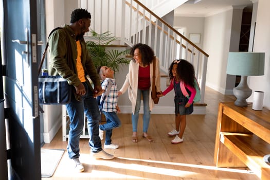 Happy african american family standing in hallway, returning back home. family time, having fun together at home.