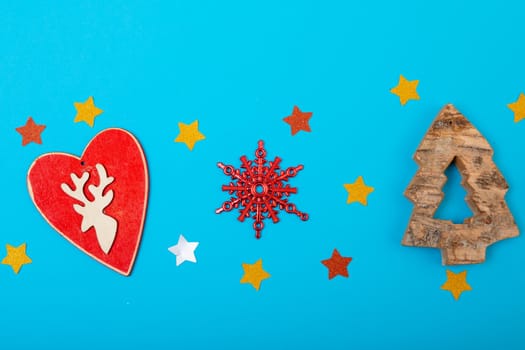 Composition of christmas decorations with heart, stars and copy space on blue background. christmas, tradition and celebration concept.