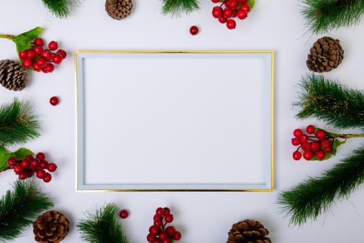 Composition of frame with copy space and fir tree branches with pine cones on white background. christmas, tradition and celebration concept.