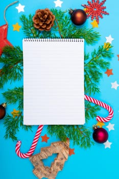 Composition of notebook with copy space and christmas decorations on blue background. christmas, tradition and celebration concept.