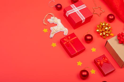 Composition of christmas decorations with baubles, presents and copy space on red background. christmas, tradition and celebration concept.