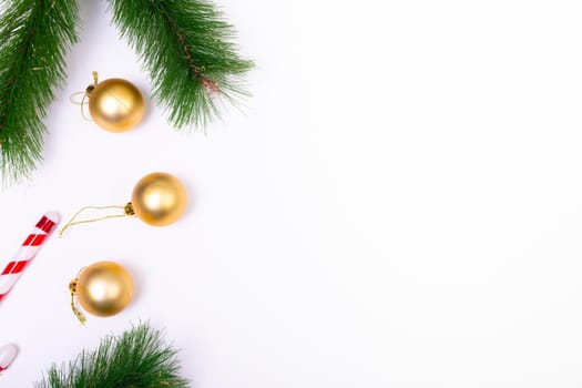 Composition of fir tree branches with baubles and copy space on white background. christmas, tradition and celebration concept.