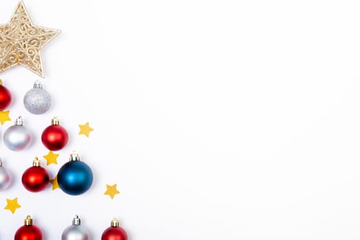 Composition of baubles with stars in shape of christmas tree and copy space on white background. christmas, tradition and celebration concept.