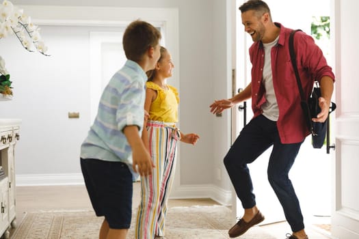 Happy caucasian father returning home with daughter and son smiling and greeting him at front door. hospitality and welcoming guests at home.