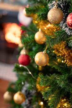 Baubles, chains and other decorations hanging on christmas tree. christmas, festivity and tradition at home.