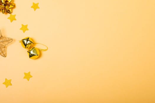 Composition of christmas decorations with bells, stars and copy space on yellow background. christmas, tradition and celebration concept.