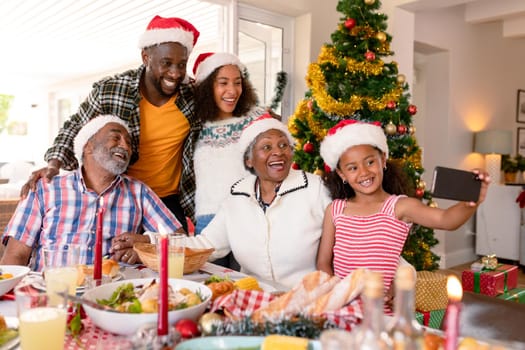 Happy multi generation family wearing santa hats, taking selfie. family christmas time and festivity together at home.