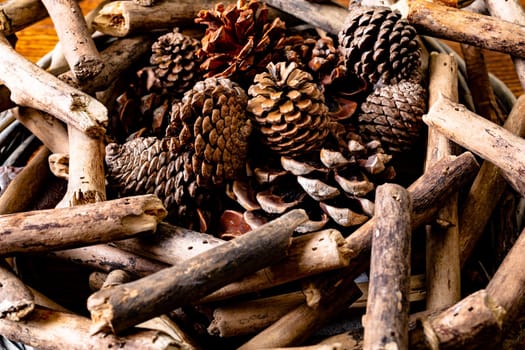 Composition of christmas decorations with sticks and pine cones on wooden background. christmas, nature, tradition and celebration concept.