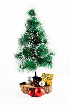 Composition of christmas decorations with fir tree and baubles on white background. christmas, tradition and celebration concept.