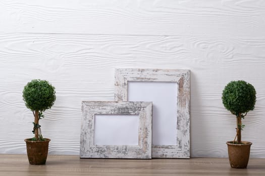 Composition of white cards in frames with copy space and decorations on white background. interior design and decor concept.