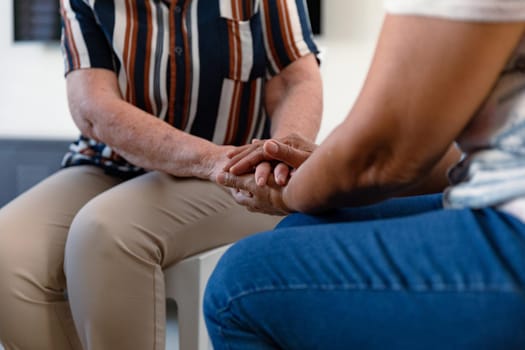 Hands of diverse senior women holding and supporting each other. senior health, support and lifestyle.