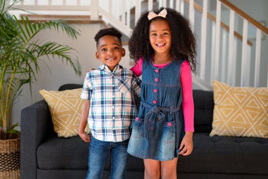 Happy african american sibling standing and looking at camera. childhood, leisure and spending time at home.