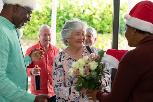 Group of happy diverse senior female and male friends meeting at christmas time. christmas festivities, celebrating at home with friends.