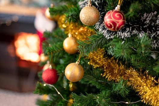 Baubles, chains and other decorations hanging on christmas tree. christmas, festivity and tradition at home.