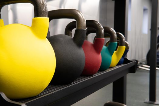 Yellow kettlebell weight background exercise, assorted colours in the afternoon workout equipment in heavy and muscle training, shape tough. Wellness pound club, inches dumbbell