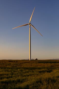 General view of wind turbine in countryside landscape with cloudless sky. environment, sustainability, ecology, renewable energy, global warming and climate change awareness.