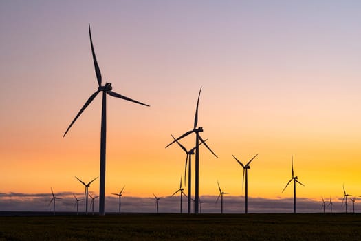 General view of wind turbines in countryside landscape during sunset. environment, sustainability, ecology, renewable energy, global warming and climate change awareness.