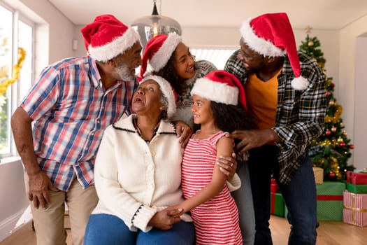 Happy multi generation family wearing santa hats, taking photo. family christmas time and festivity together at home.