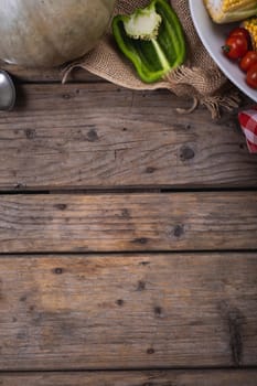 Close up of multiple food ingredients and cutlery with copy space on wooden surface. food and restaurant concept