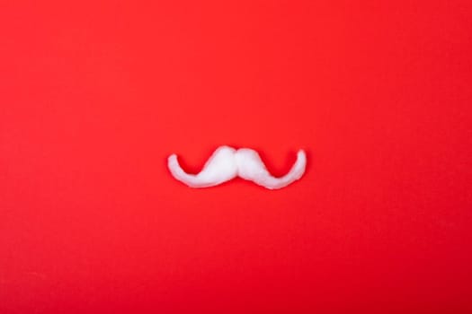Composition of white santa claus moustache with copy space on red background. christmas, tradition and celebration concept.