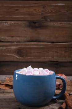 White and pink marshmallows in hot chocolate drink with copy space wooden background. cafe culture, hot chocolate drink.