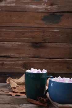 Marshmallows with hot chocolate drink in mugs on wooden table with copy space. hot chocolate drink, cafe culture.