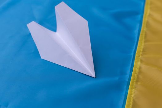 paper airplane on the background flag of Ukraine, flags of the country, blue, yellow.