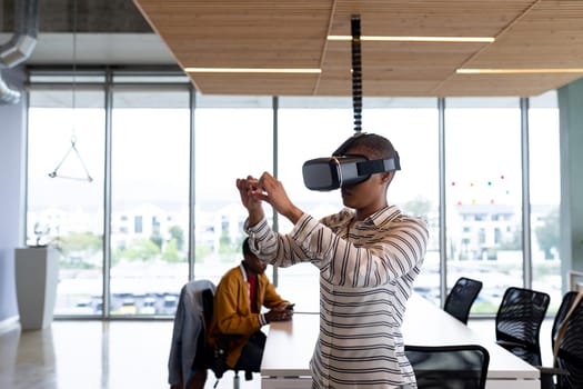 Creative businesswoman in casual gesturing while using virtual reality headset in office. creative design business, innovation and futuristic.